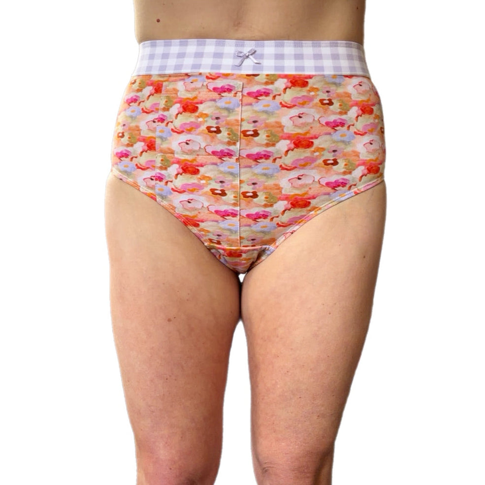 A person wearing high-waisted underwear with a colorful floral print and a white-and-purple gingham waistband, shown against a plain white background.