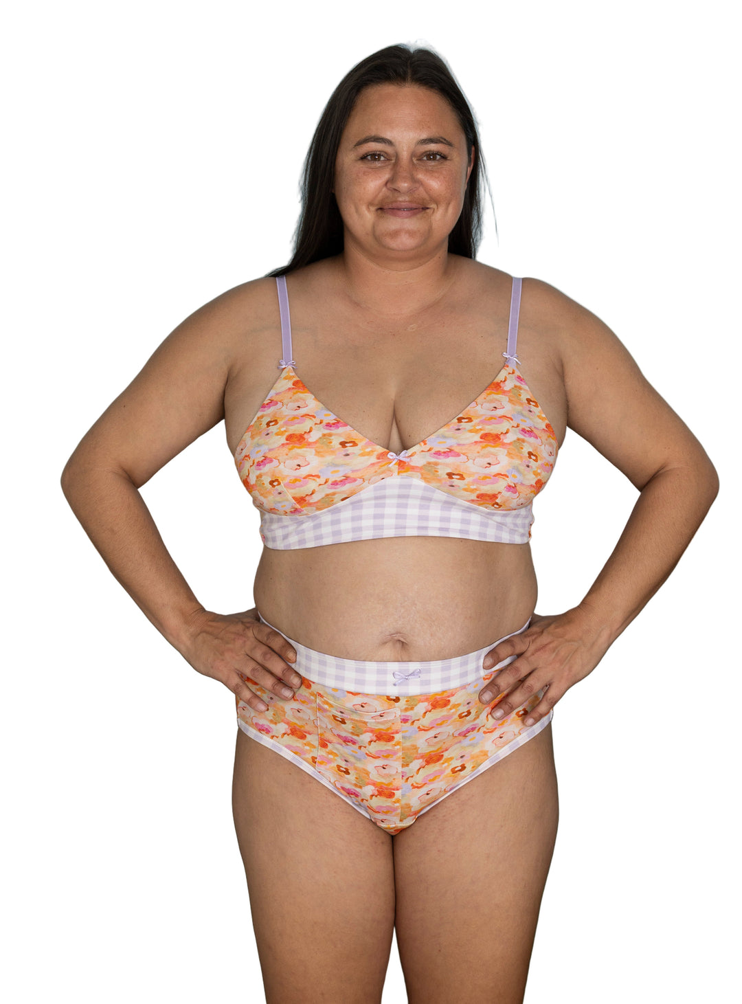 A woman wearing high-waisted discharge underwear with a floral and gingham pattern and matching bralette.