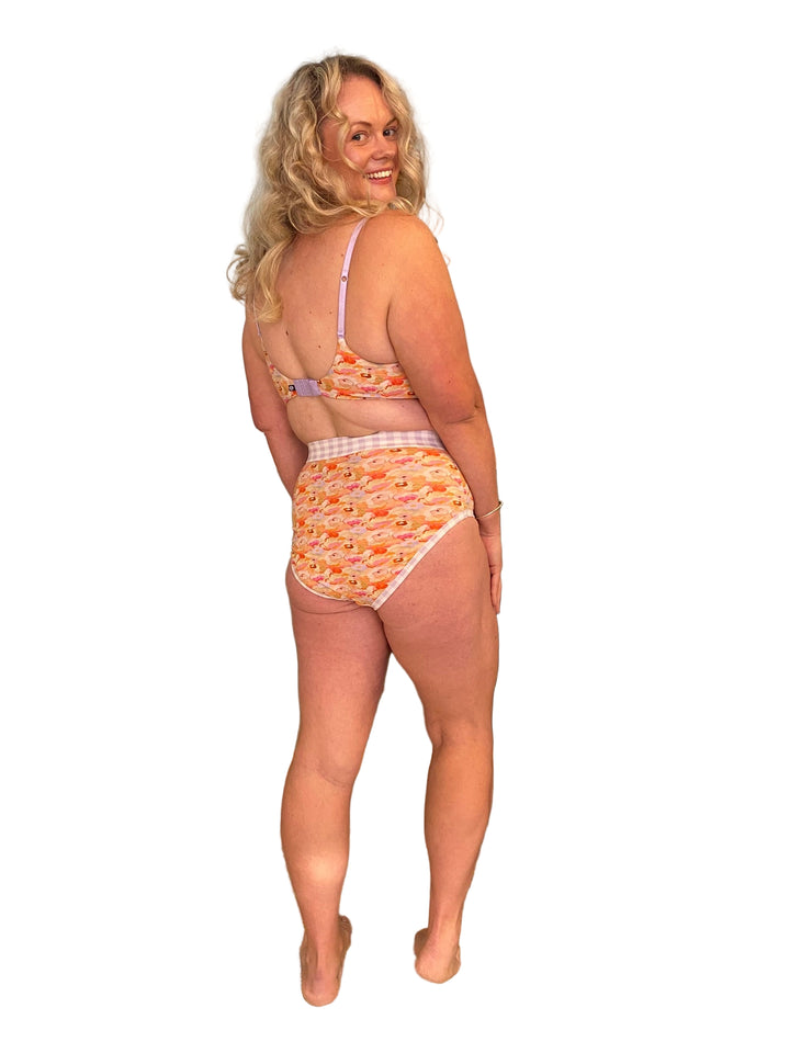 A woman wearing high-waisted discharge underwear with a floral and gingham pattern.
