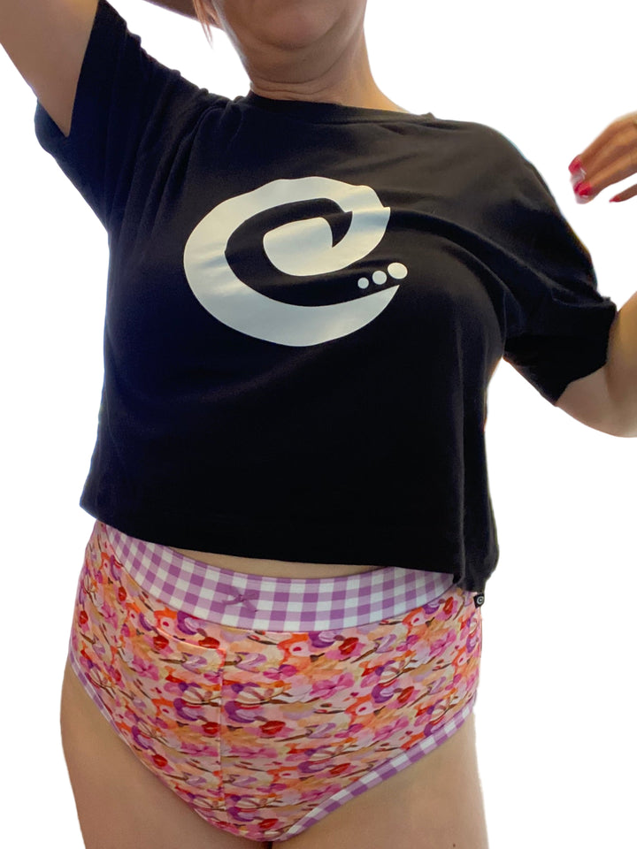 A woman wearing high-waisted discharge underwear with a floral pattern and gingham waistband.